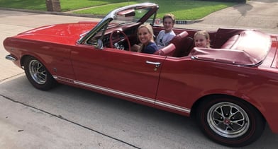 alt="woman and children sitting in ford mustang"