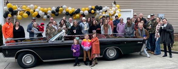 alt="Family celebrating in front of a Lincoln Continental"